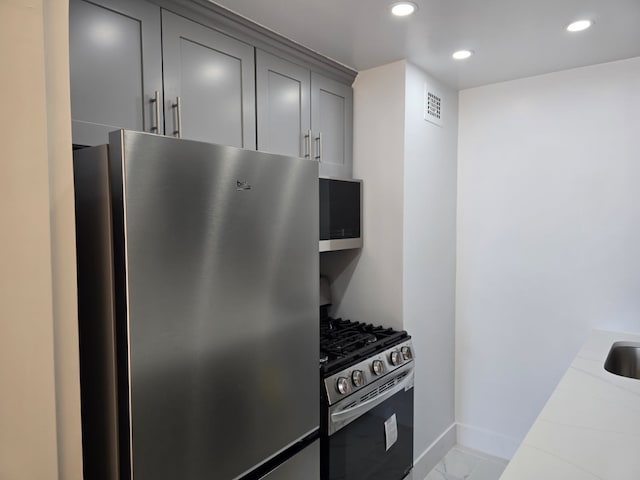 310 E 46th St Unit 18J, New York City, NY 10017 - kitchen featuring stainless steel appliances, recessed lighting, gray cabinets, and tile counters