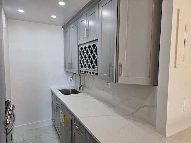 310 E 46th St Unit 18J, New York City, NY 10017 - laundry room featuring recessed lighting, light marble finish floors, and wet bar