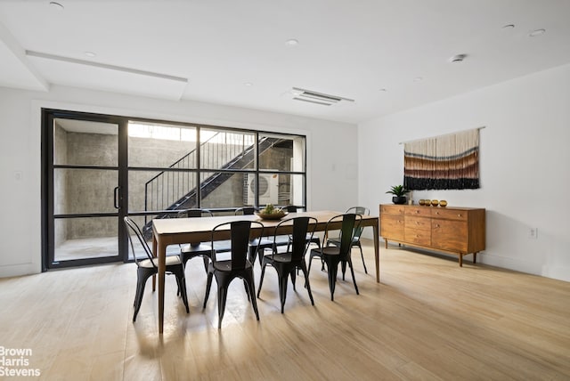 dining space featuring light wood-style flooring and baseboards