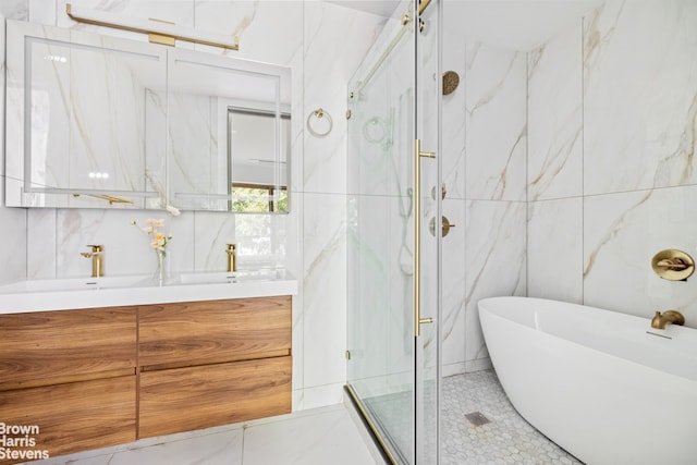 full bathroom featuring a marble finish shower, tile walls, double vanity, a freestanding bath, and tile patterned flooring
