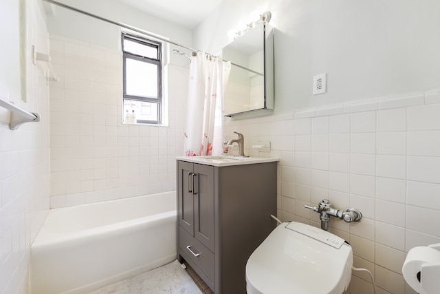 bathroom with tile walls, toilet, shower / bath combination with curtain, vanity, and wainscoting