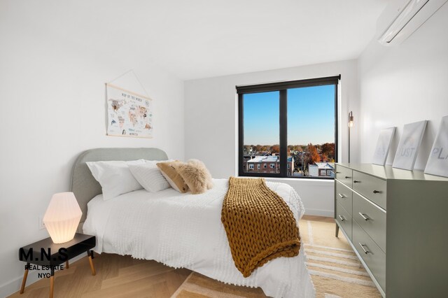 22-54 46th St Unit 704, New York City, NY 11105 - bedroom featuring an AC wall unit and baseboards