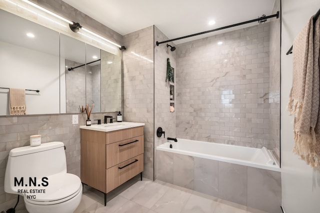22-54 46th St Unit 704, New York City, NY 11105 - full bath with tiled shower / bath combo, toilet, vanity, tile walls, and marble finish floors