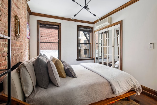 bedroom featuring baseboards, ornamental molding, wood finished floors, and a wall mounted air conditioner