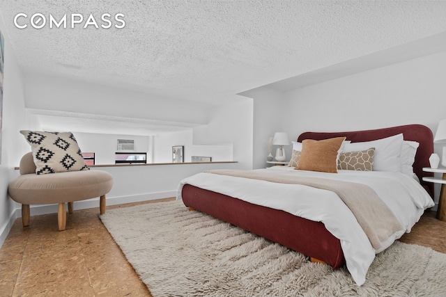 bedroom with a textured ceiling and baseboards