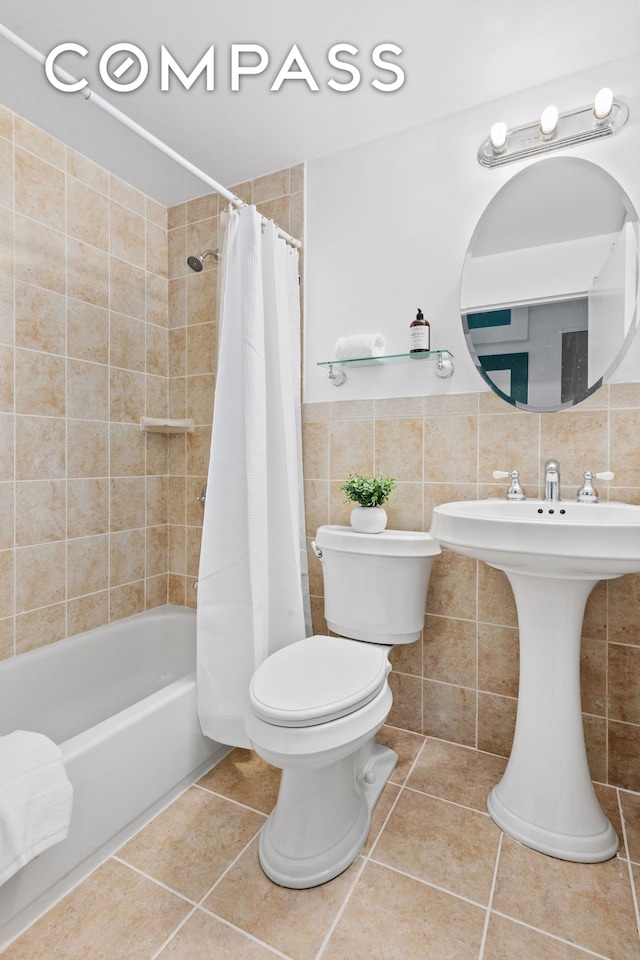 372 5th Ave Unit 9J, New York City, NY 10018 - full bathroom featuring toilet, tile patterned flooring, shower / bathtub combination with curtain, and tile walls