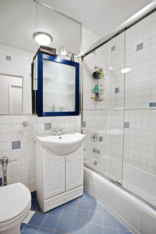 301 E 69th St Unit 15K, New York City, NY 10021 - bathroom with tile walls, combined bath / shower with glass door, toilet, tile patterned flooring, and vanity