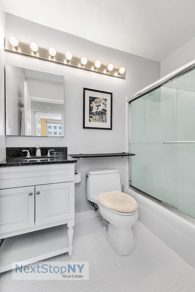 245 E 54th St Unit 22A, New York City, NY 10022 - bathroom with toilet, vanity, shower / bath combination with glass door, and tile patterned flooring