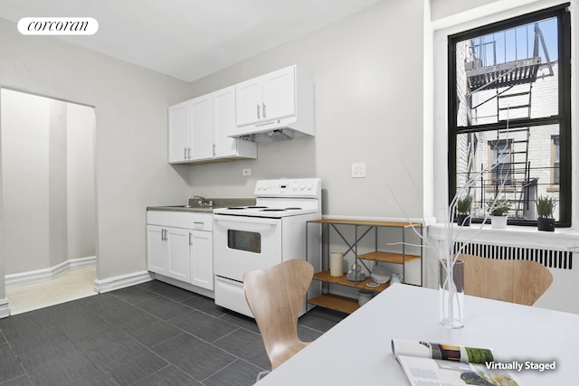 kitchen featuring white cabinets, white range with electric cooktop, under cabinet range hood, dark tile patterned flooring, and visible vents