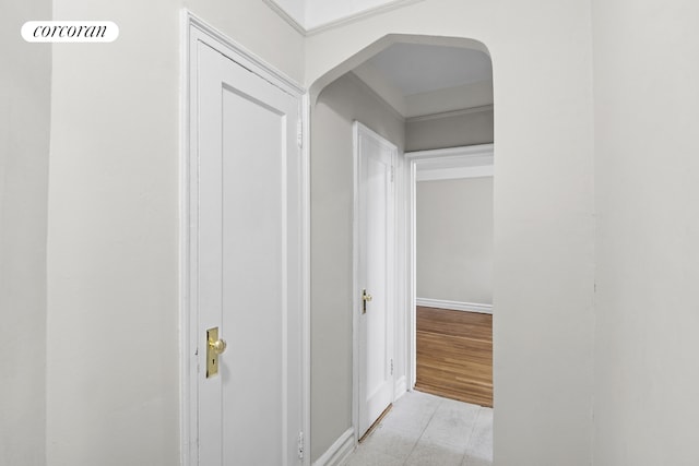 hallway with arched walkways and baseboards