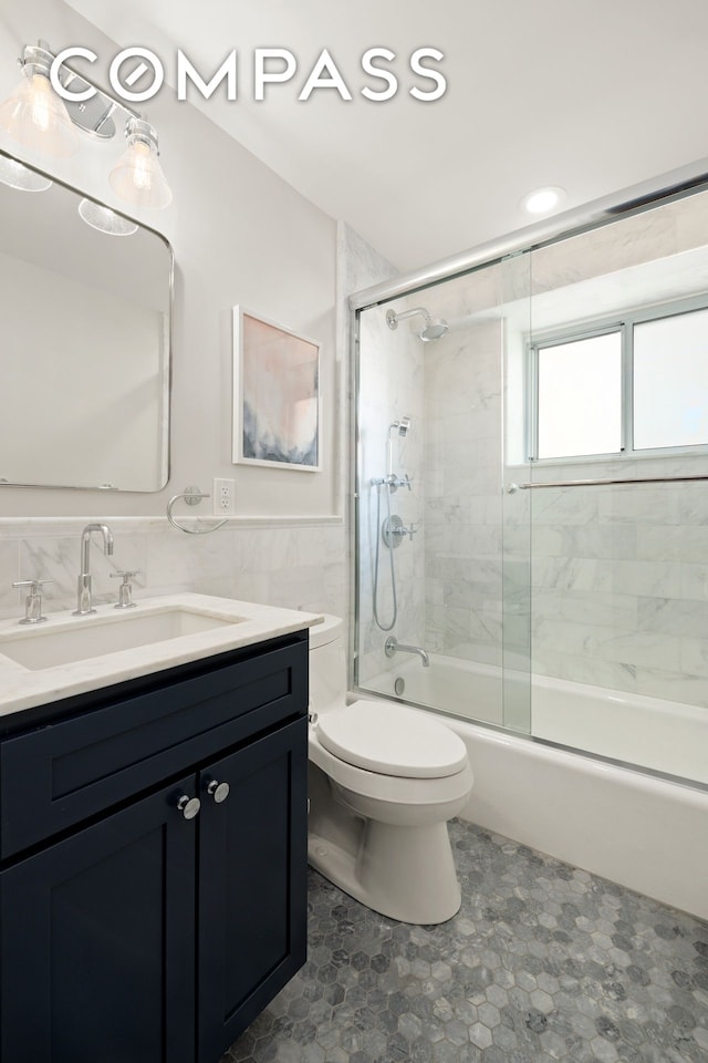 420 E 58th St Unit 14B, New York City, NY 10022 - bathroom featuring vanity, enclosed tub / shower combo, and tile walls