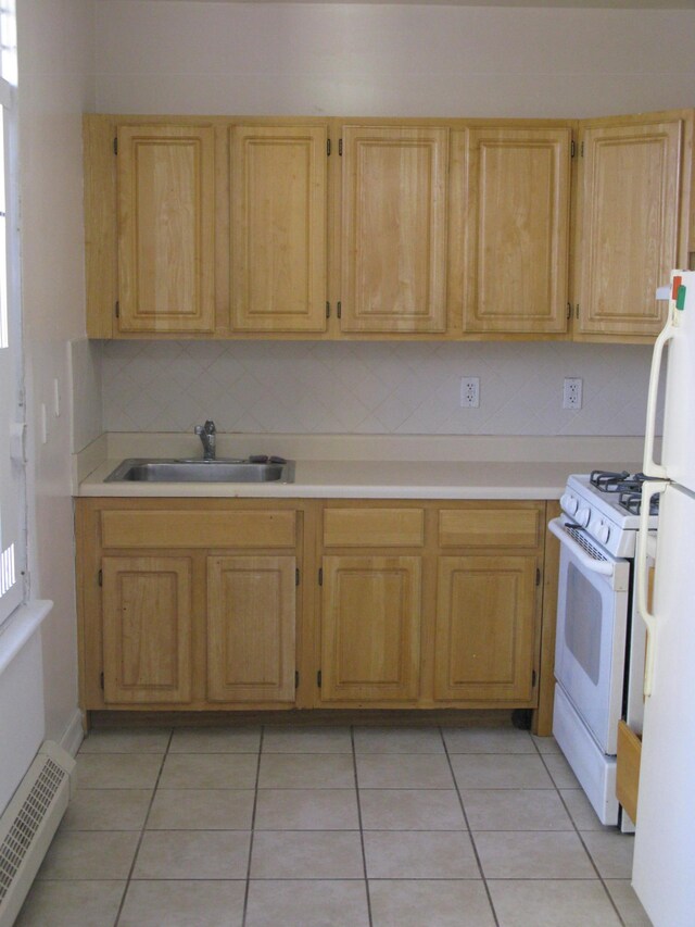 157 Broome St Unit 5-E, New York City, NY 10002 - kitchen with white appliances, a sink, a baseboard heating unit, light tile patterned floors, and light countertops