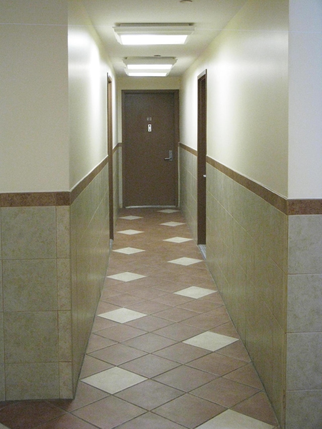157 Broome St Unit 5-E, New York City, NY 10002 - hall with tile walls and a wainscoted wall
