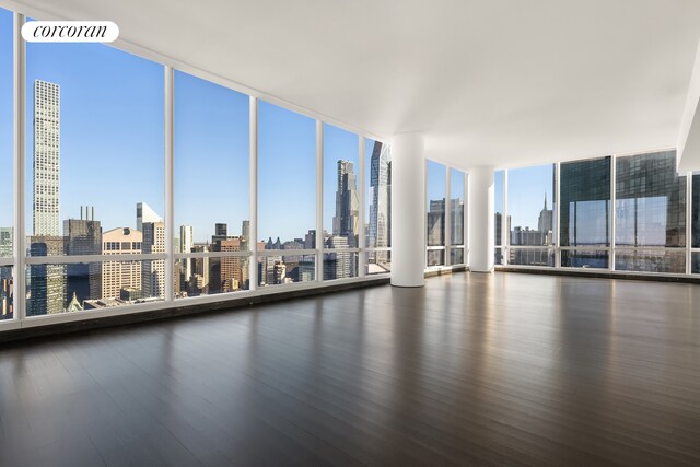 157 W 57th St Unit 56C, New York City, NY 10019 - spare room with expansive windows, a city view, wood finished floors, and visible vents