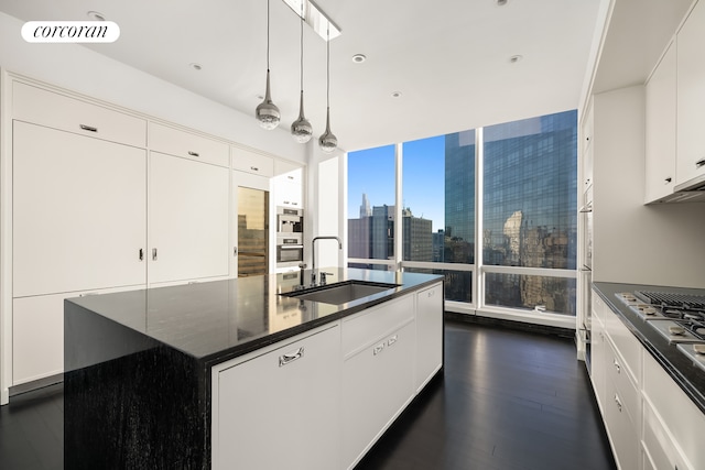 157 W 57th St Unit 56C, New York City, NY 10019 - kitchen featuring a sink, hanging light fixtures, a view of city, dark wood-type flooring, and visible vents