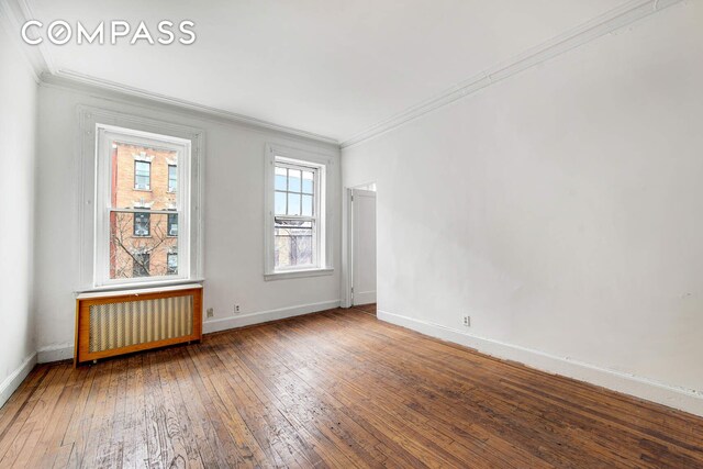 337 E 18th St, New York City, NY 10003 - spare room featuring crown molding, baseboards, radiator heating unit, and hardwood / wood-style floors