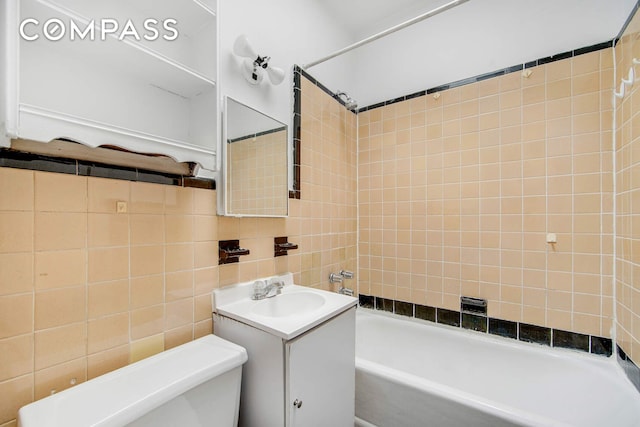 337 E 18th St, New York City, NY 10003 - full bathroom with tile walls, vanity, toilet, and bathtub / shower combination