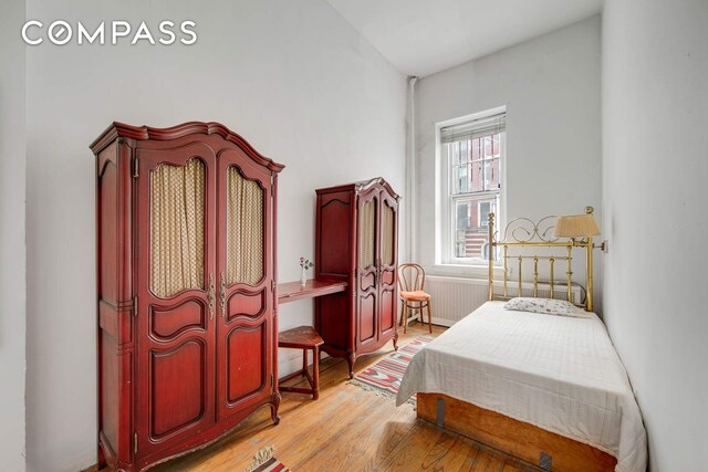 337 E 18th St, New York City, NY 10003 - bedroom with radiator heating unit and light wood-type flooring
