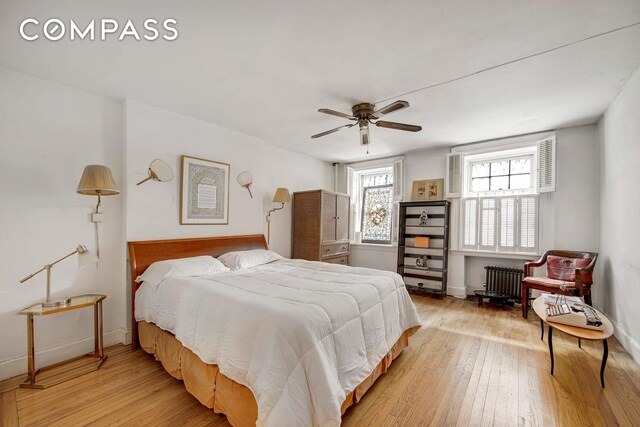 337 E 18th St, New York City, NY 10003 - bedroom featuring baseboards, a ceiling fan, radiator heating unit, and light wood-style flooring