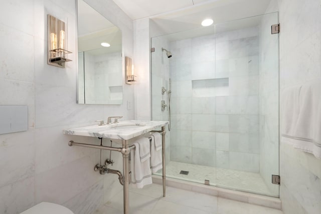 full bathroom with toilet, tile walls, a sink, and a stall shower