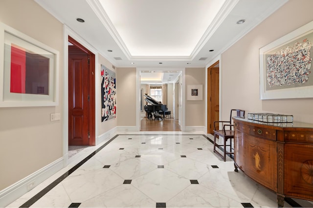 hallway featuring recessed lighting, a tray ceiling, baseboards, and crown molding