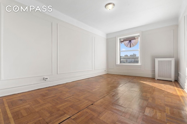 unfurnished room with a decorative wall and radiator