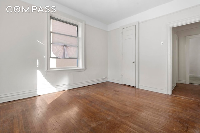 unfurnished bedroom featuring hardwood / wood-style floors and baseboards