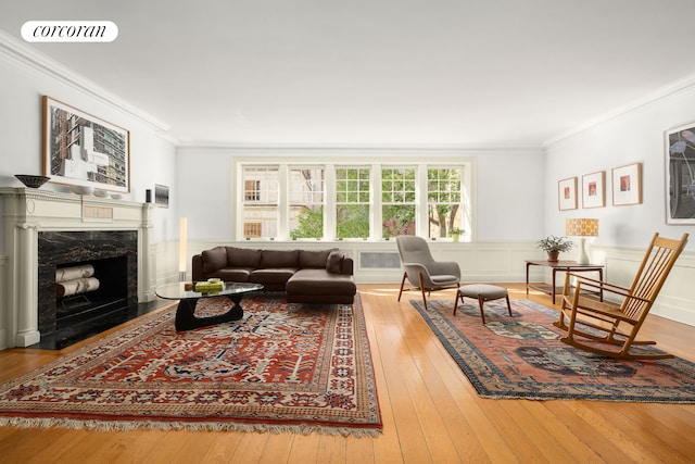 living room with crown molding, visible vents, wood-type flooring, and a fireplace