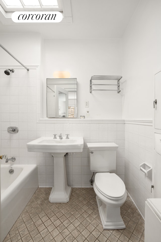 bathroom featuring toilet, shower / tub combination, tile patterned flooring, and tile walls