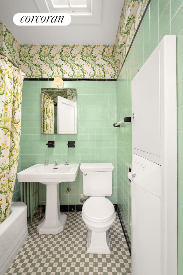 full bathroom featuring toilet, wallpapered walls, and tile walls
