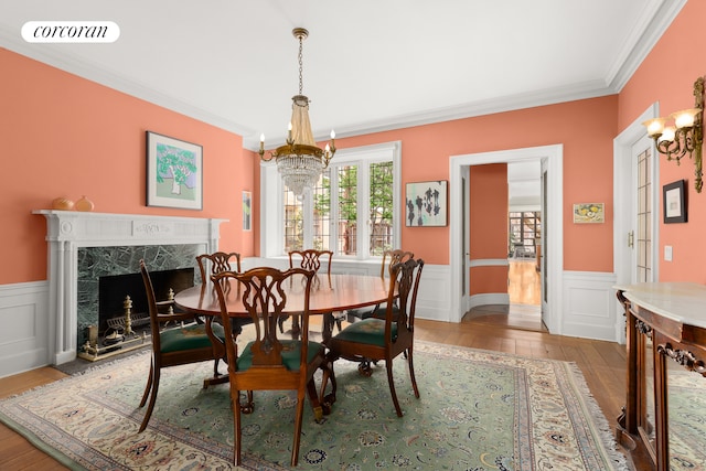 dining area with ornamental molding, visible vents, hardwood / wood-style floors, and a notable chandelier