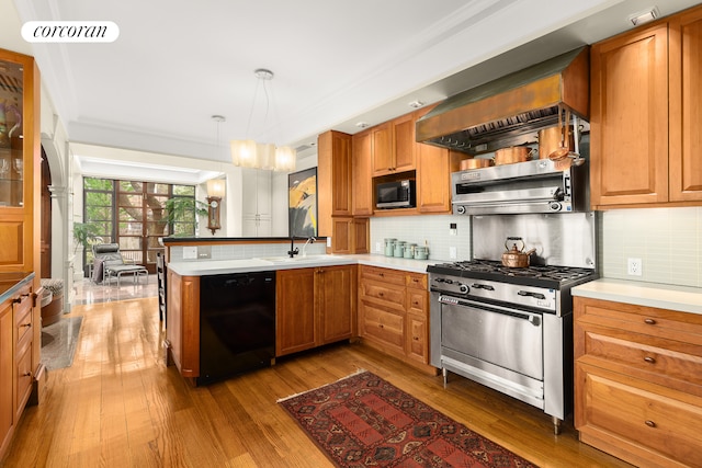 kitchen with a peninsula, visible vents, appliances with stainless steel finishes, a sink, and wood finished floors