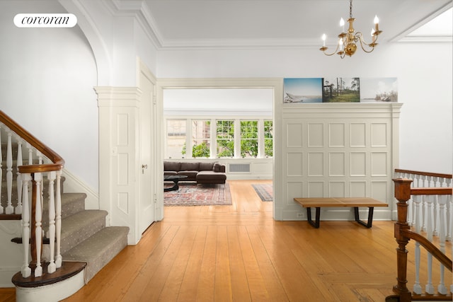 interior space featuring a chandelier, crown molding, stairs, light wood-style floors, and visible vents