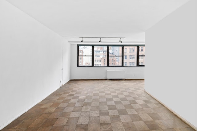 225 E 36th St Unit 11R, New York City, NY 10016 - unfurnished room featuring radiator and rail lighting