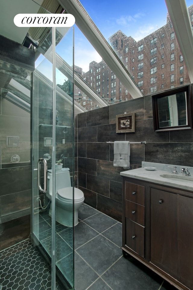 443 W 24th St Unit G, New York City, NY 10011 - full bathroom featuring tile walls, tile patterned flooring, vanity, a shower stall, and toilet