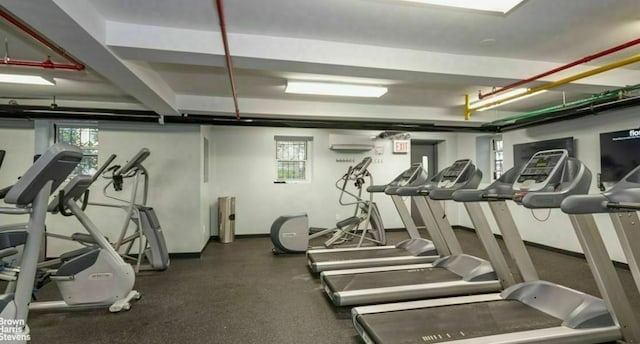 gym featuring healthy amount of natural light and baseboards