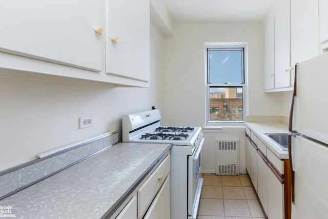3750 Hudson Manor Ter Unit 6Hw, New York City, NY 10463 - kitchen with white appliances, radiator, white cabinets, and light countertops