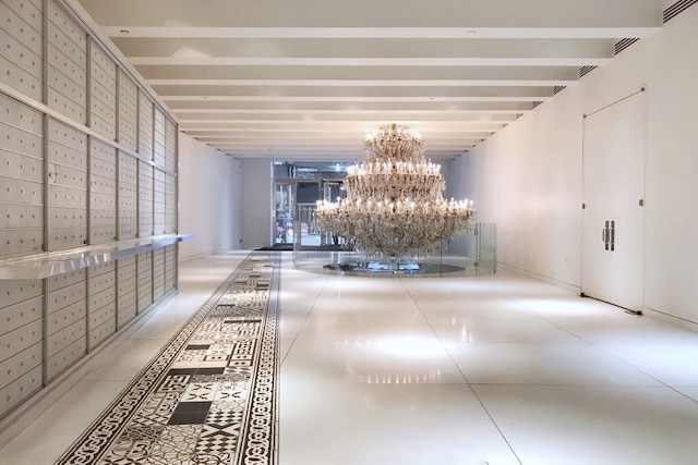 hall with a chandelier, light tile patterned floors, and visible vents