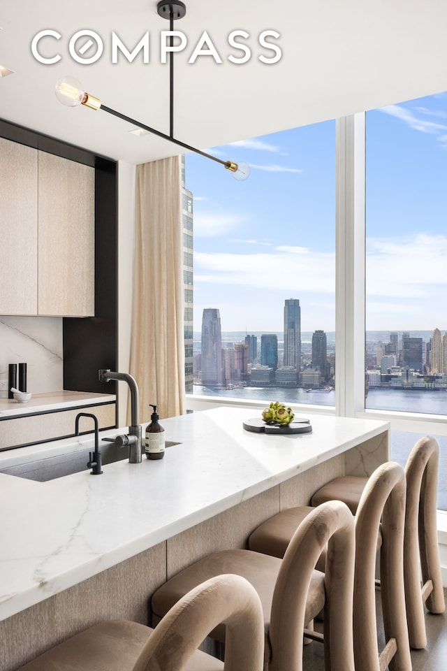 kitchen with a city view, a kitchen bar, a sink, and modern cabinets