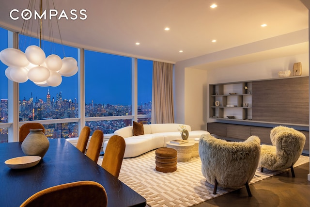 living room featuring recessed lighting, a city view, wood finished floors, and floor to ceiling windows