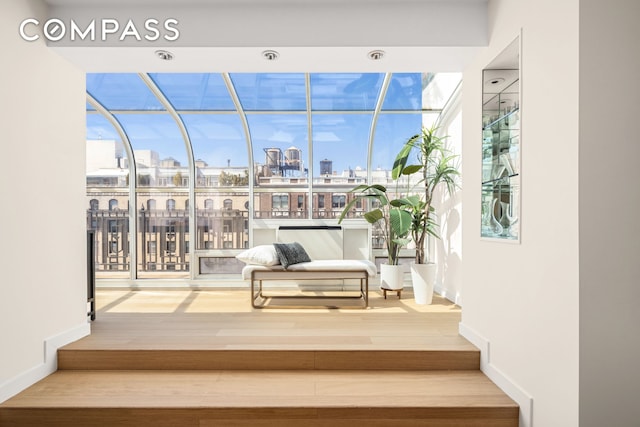 1049 Park Ave Ph, Ph, New York City, NY 10028 - stairway featuring a skyline view, wood finished floors, and baseboards