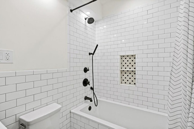 bathroom featuring tiled shower / bath combo, tile walls, and toilet