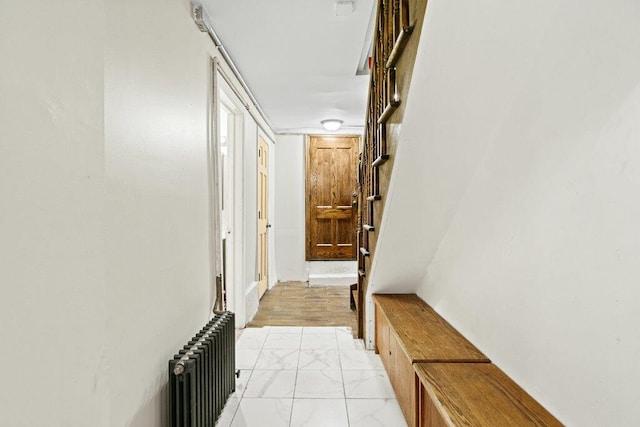 corridor with marble finish floor and radiator heating unit