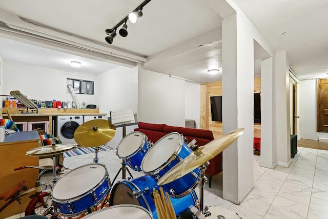 recreation room featuring marble finish floor and washer / dryer