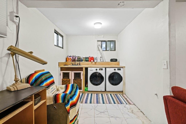 laundry room featuring washing machine and clothes dryer, laundry area, and a sink