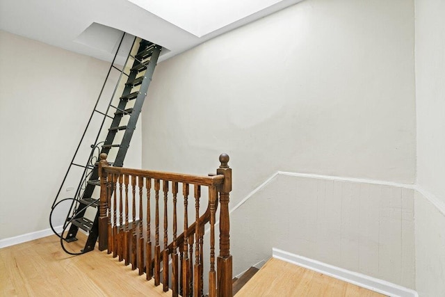 staircase with baseboards and wood finished floors