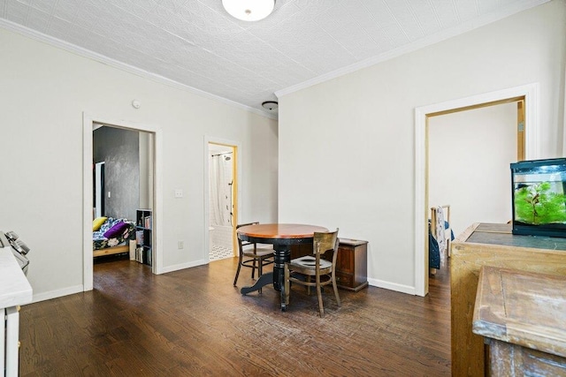 dining space featuring crown molding, baseboards, and wood finished floors