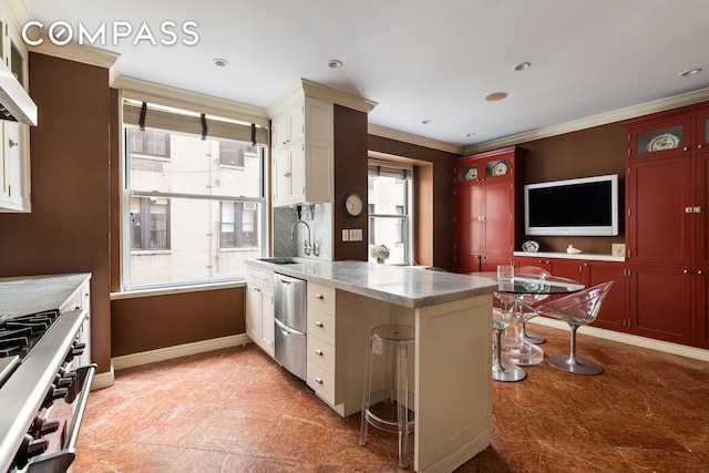 875 Park Ave Unit 9C, New York City, NY 10075 - kitchen with range, stainless steel dishwasher, a peninsula, crown molding, and wall chimney exhaust hood