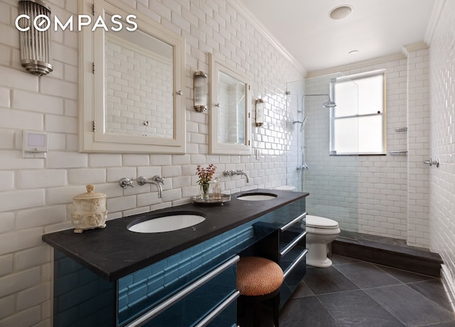 875 Park Ave Unit 9C, New York City, NY 10075 - bathroom featuring tiled shower, double vanity, tile walls, tile patterned floors, and crown molding