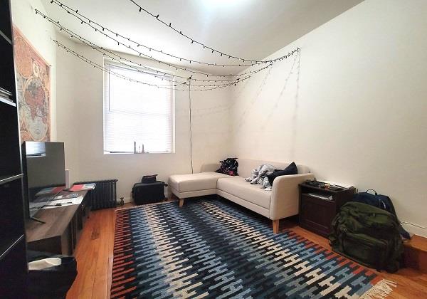 21-05 33rd St Unit 1-G, New York City, NY 11105 - living area with wood finished floors, an office area, and radiator heating unit